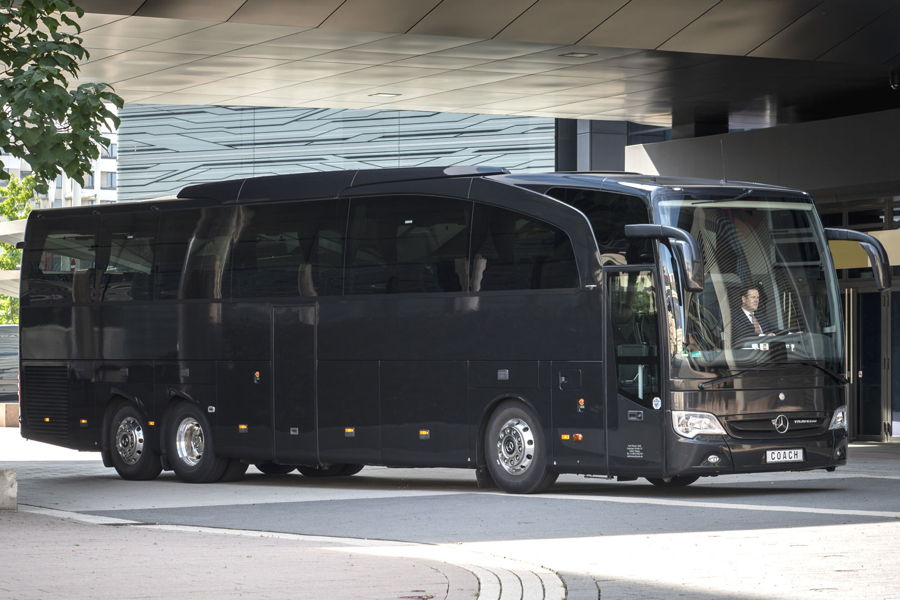 Bus Reisebus Ein schwarzer Mercedes-Benz Travego Konferenz Reisebus vor einem Hotel.